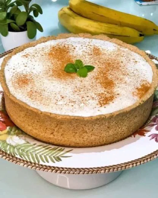 Torta banoffee inteira polvilhada com canela, sobre a mesa